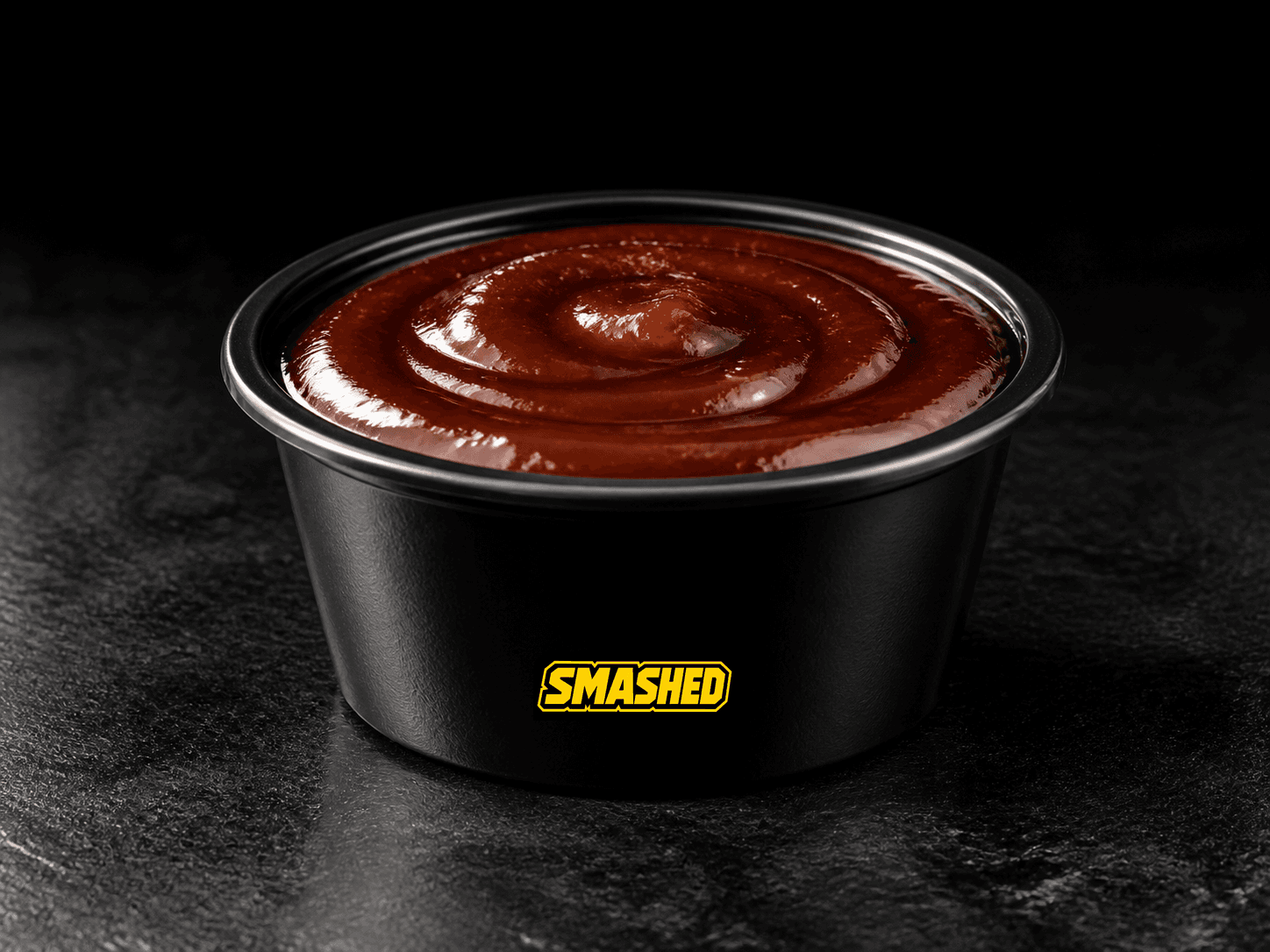 BBQ sauce cup on a black counter