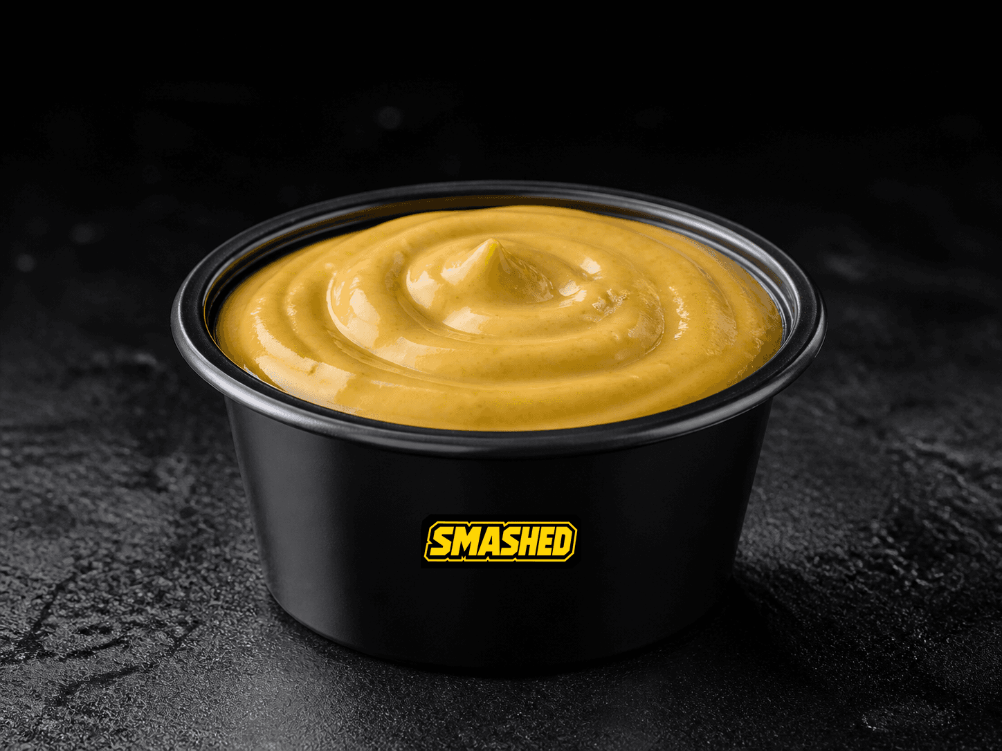 Honey mustard sauce cup on a black counter