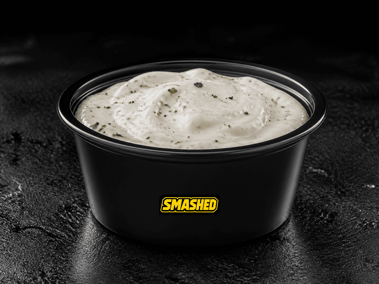 Ranch sauce cup on a black counter