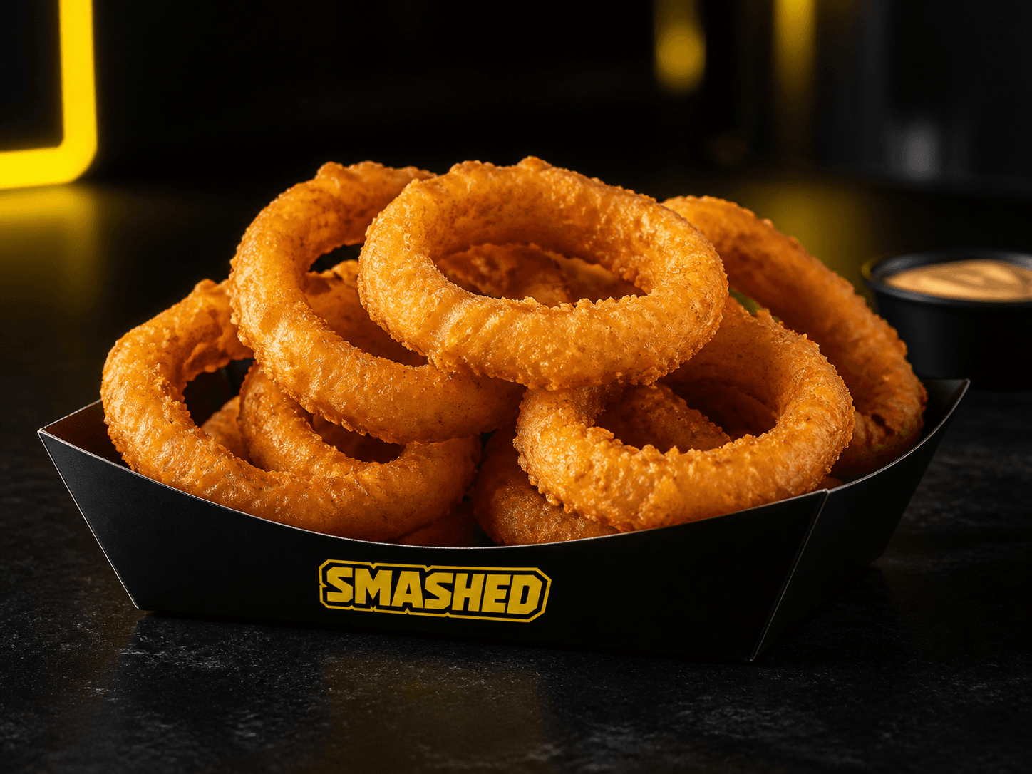 Crispy onion rings in a black SMASHED box